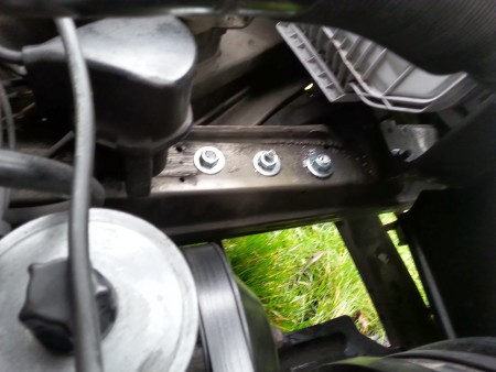 Voor de stalen bodemplaat en extra sleepogen is met grote bouten een versterking onder de auto gemaakt.